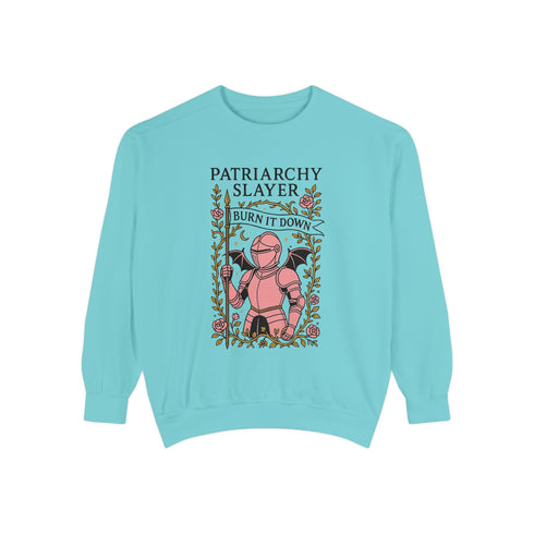 Comfort Colors garment-dyed sweatshirt featuring 'Patriarchy Slayer' design with pink armored knight holding sword and banner reading 'Burn It Down', surrounded by decorative floral border with roses and leaves. Made from 80% ring-spun cotton and 20% polyester with relaxed fit and rolled-forward shoulders. Available in lavender purple and seafoam green colorways, sizes S-3XL unisex, featuring sustainable made-to-order production with OEKO-TEX certified low-impact dyes and zero waste manufacturing process.